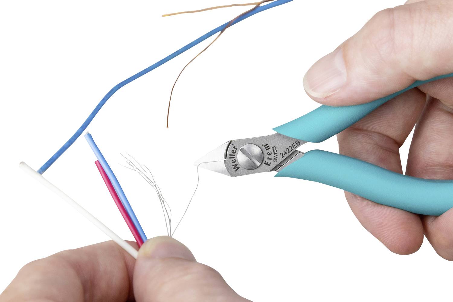 'Jedna ręka trzyma szczypce boczne, które przecinają niebieski kabel. W tle widoczne są kolejne kolorowe kable.'