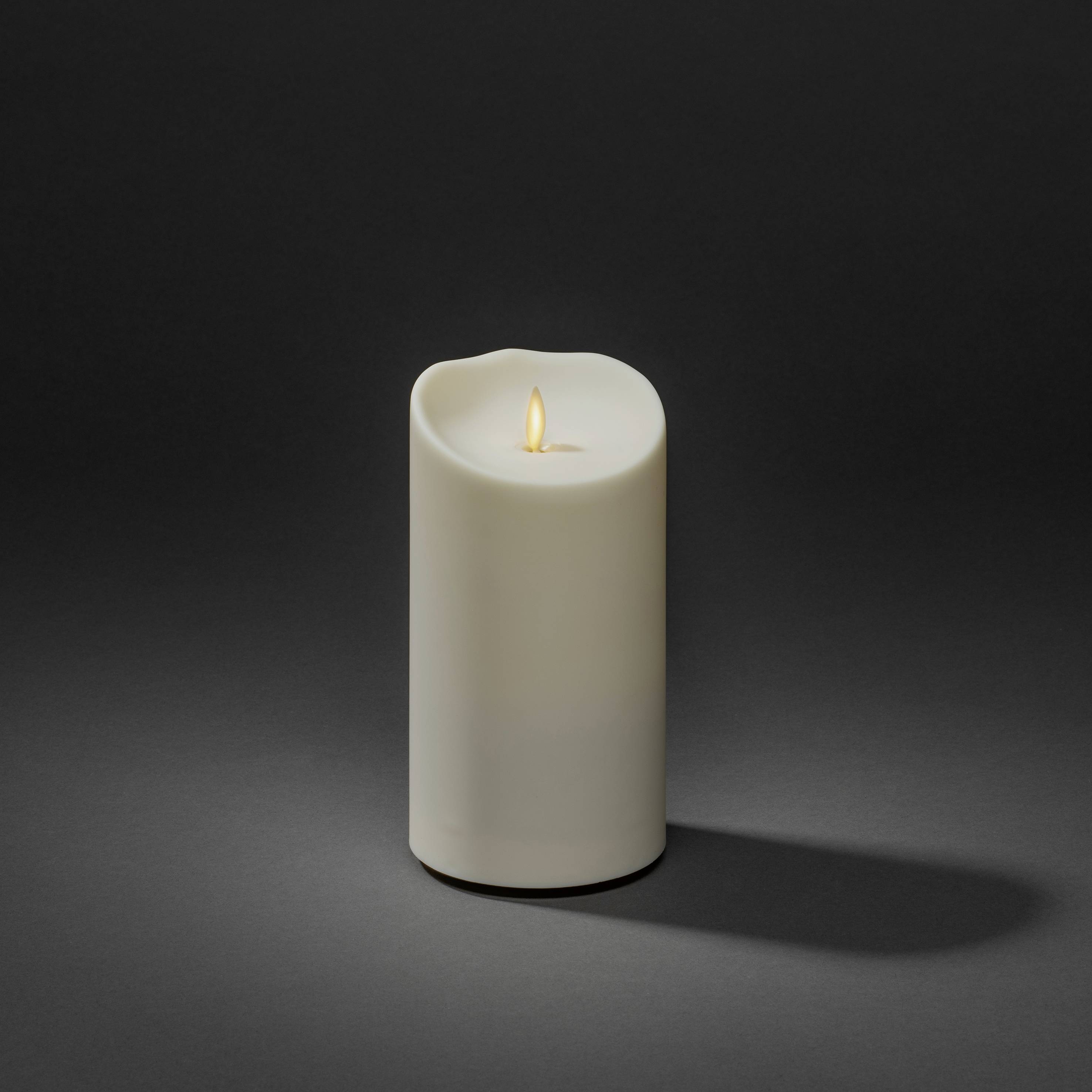 Biała świeca LED z migoczącym światłem na szarym tle. Wyglądająca oszukańczo prawdziwie, z naturalną optyką płomienia.
