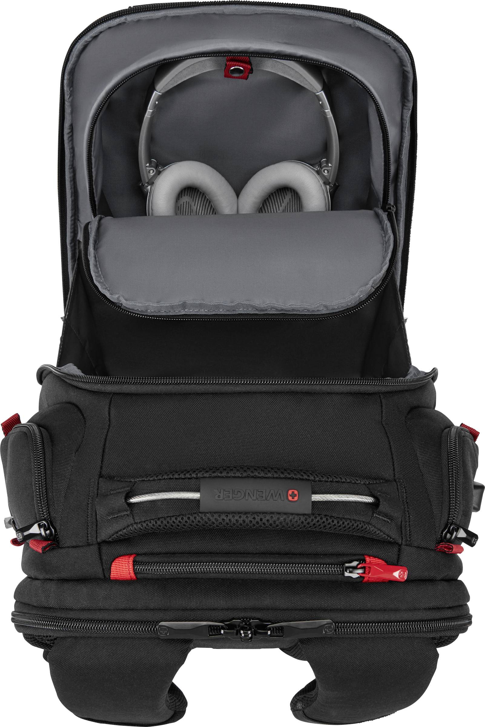 Czarny plecak z otwartymi przegrodami, ukazującymi słuchawki i elektroniczne akcesoria. Czerwone akcenty i kilka kieszeni zamykanych na zamek błyskawiczny.