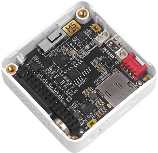 Moduł rozwojowy M5Stack z widocznymi obwodami elektronicznymi i złączami, umieszczony na kwadratowej płytce bazowej.
