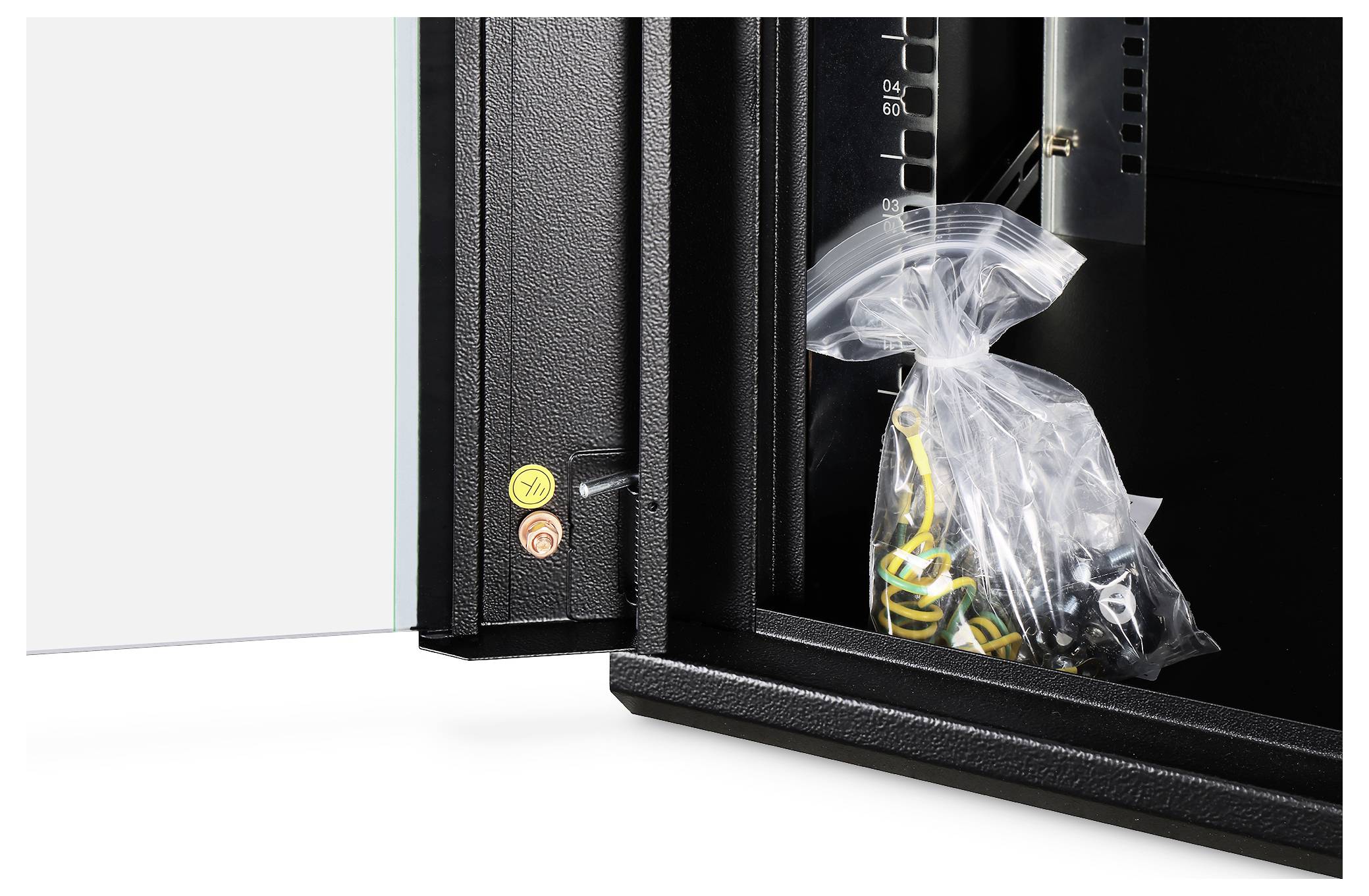 Sejf jest otwarty, widać w nim plastikową torbę z kablami. Na drzwiczkach znajdują się małe naklejki ostrzegawcze.