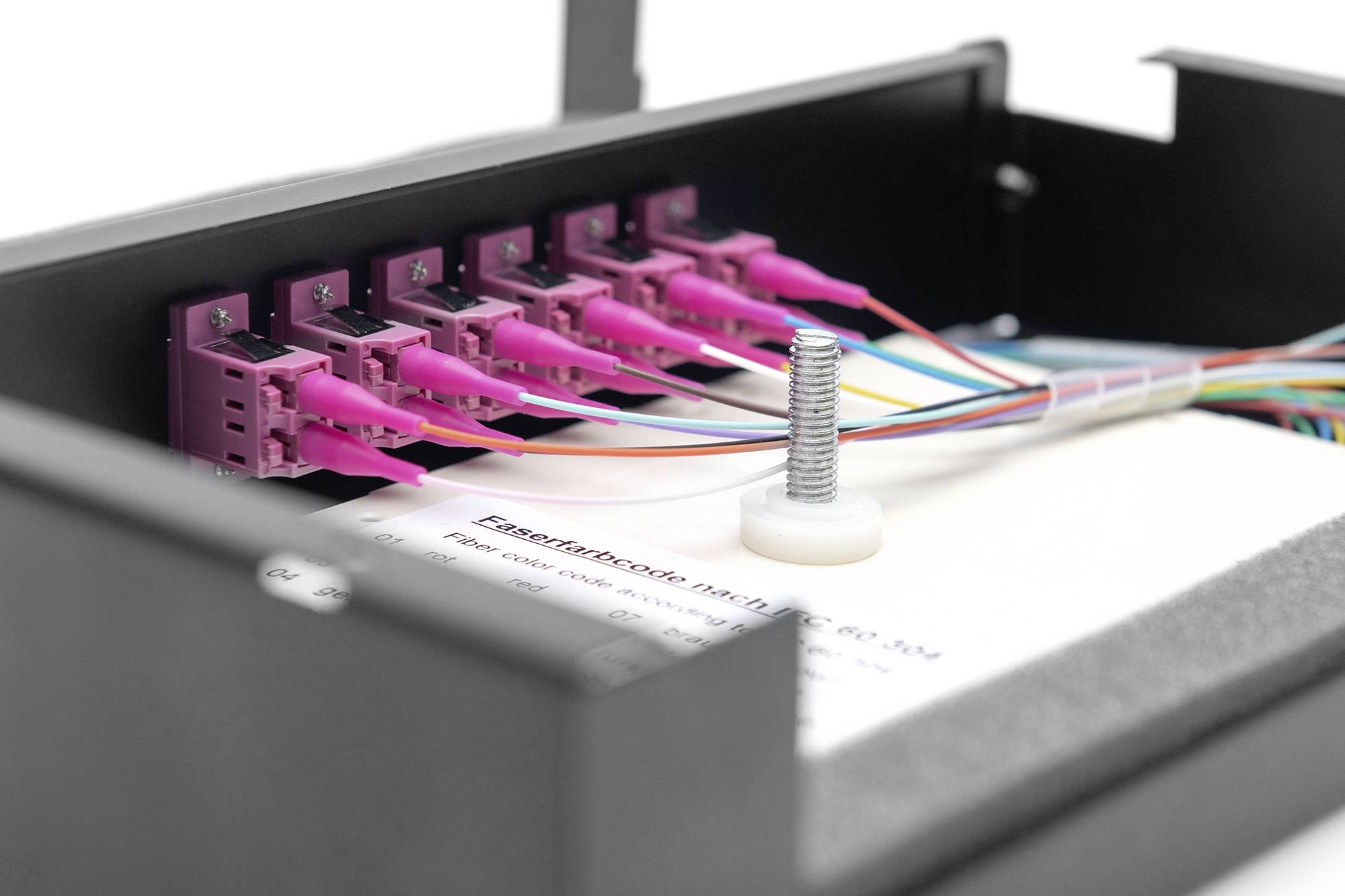 'Zbliżenie rozdzielacza światłowodowego z wieloma podłączonymi kablami, prezentujące szczegółowy widok połączeń.'