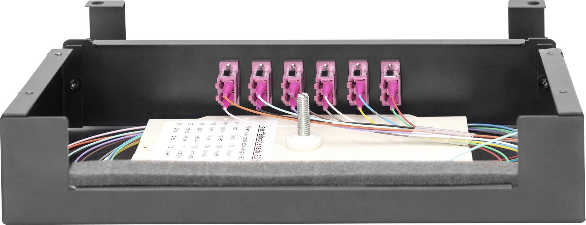 Czarna obudowa z kilkoma różowymi wtyczkami, kolorowymi kablami i jedną śrubą pośrodku. W tle widać kartkę z notatkami.