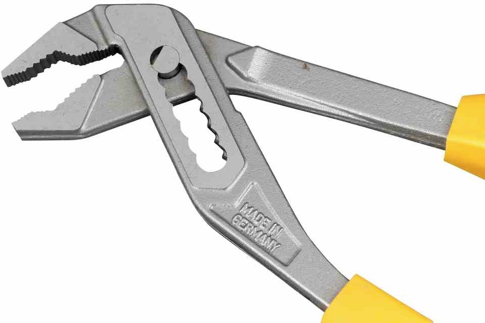 Nastawiane szczypce do rur z szarego metalu z żółtymi uchwytami. Na narzędziu wygrawerowano napis 'Made in Germany'.