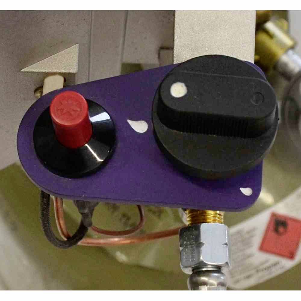 Maszyna z fioletową osłoną, czerwonym przyciskiem i czarnym przełącznikiem. Widoczne przewody miedziane i śruby.