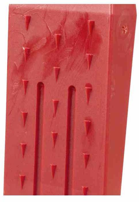 Czerwony, prostokątny obiekt z trójkątami skierowanymi do wewnątrz na powierzchni, przypominający uchwyt lub część narzędzia.