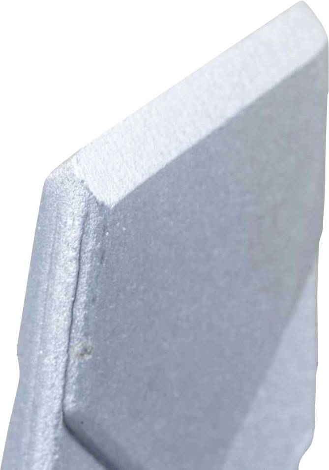 Zbliżenie ostro zakończonej części metalowej z fazowanymi krawędziami.