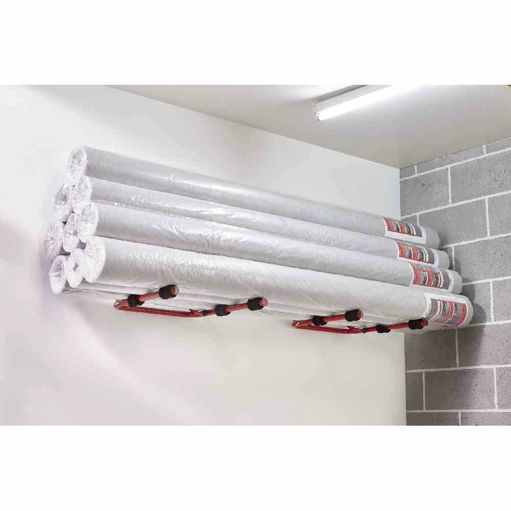 Sześć rolek izolacyjnych zapakowanych w plastik zamocowanych jest na uchwycie ściennym w garażu lub pomieszczeniu magazynowym.