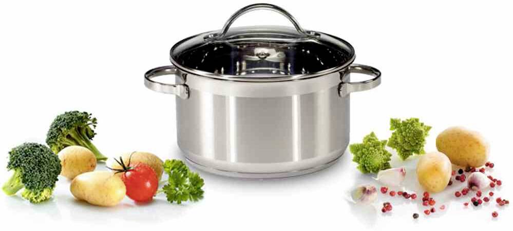 Stalowy garnek ze szklaną pokrywką stoi pośrodku, otoczony świeżymi warzywami takimi jak brokuły, ziemniaki, pomidory i rzodkiewki.