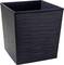 Czarny, prostokątny pojemnik o fakturowanej powierzchni, używany jako kosz na śmieci.