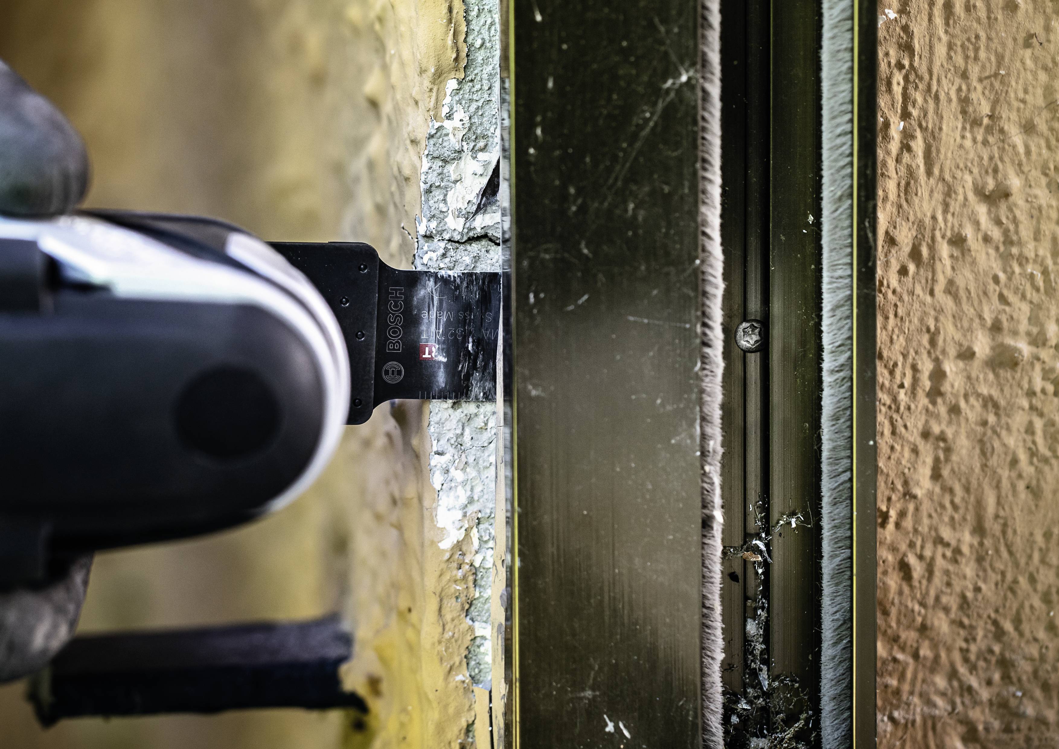 Piła oscylacyjna precyzyjnie przesuwa się wzdłuż krawędzi metalowej ramy.