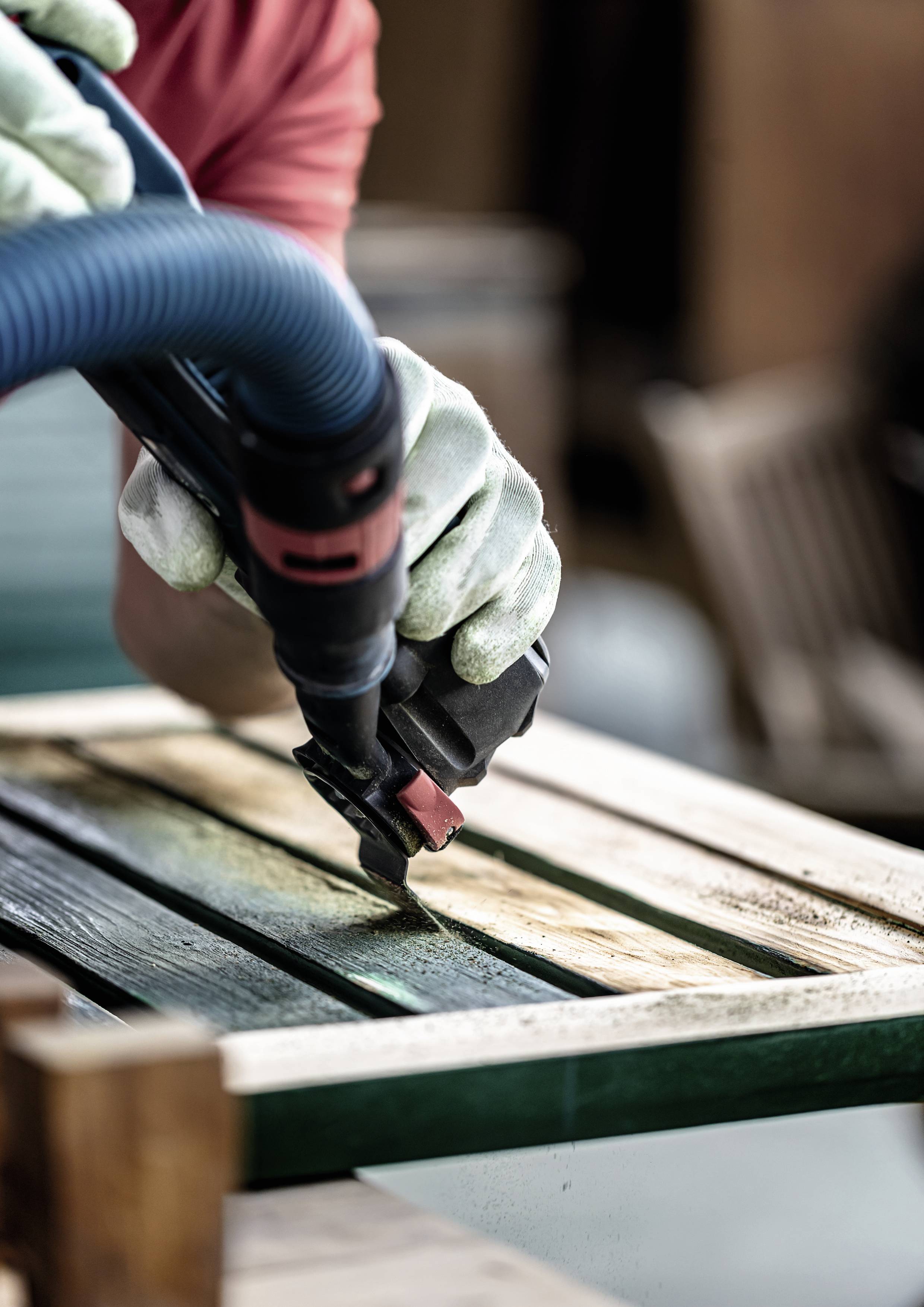 Osoba szlifuje drewniany frame drzwi za pomocą szlifierki. Zbliżenie pokazuje rękawice i narzędzie, tworząc gładką powierzchnię poprzez szlifowanie.
