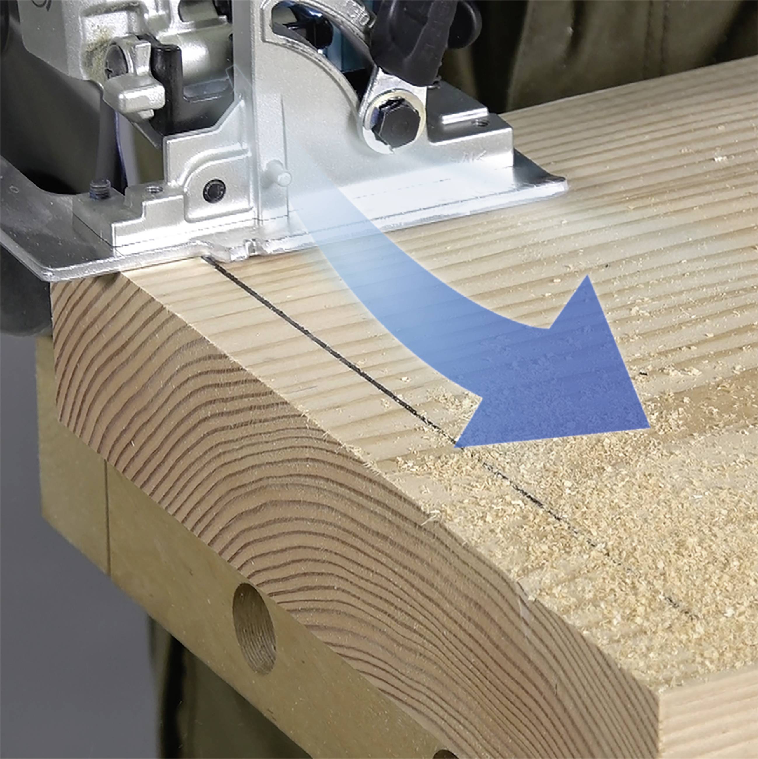 Elektryczna piła przecina wzdłuż linii deskę drewnianą. Niebieski strzałka wskazuje kierunek ruchu cięcia.