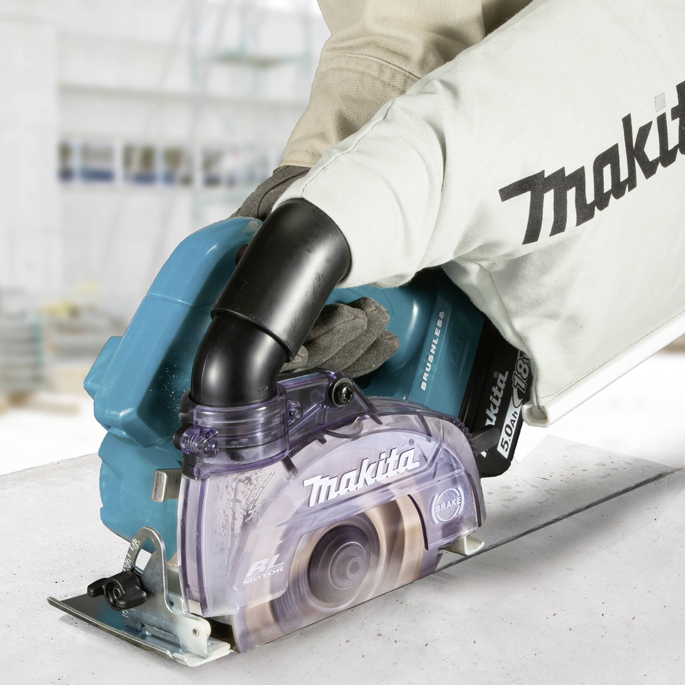 Osoba pracuje niebieską ręczną piłą tarczową Makita na białym blacie roboczym.