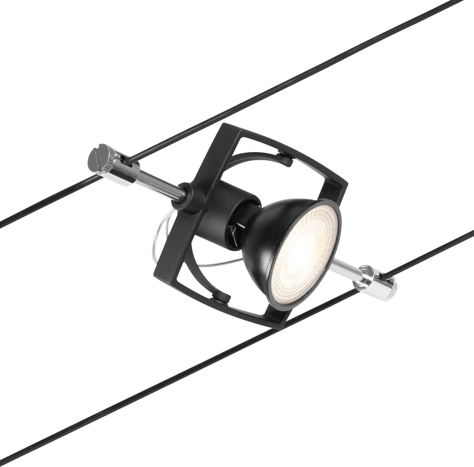 Czarna lampa wisi na dwóch równolegle biegnących przewodach. Źródło światła jest okrągłe i skierowane w dół.