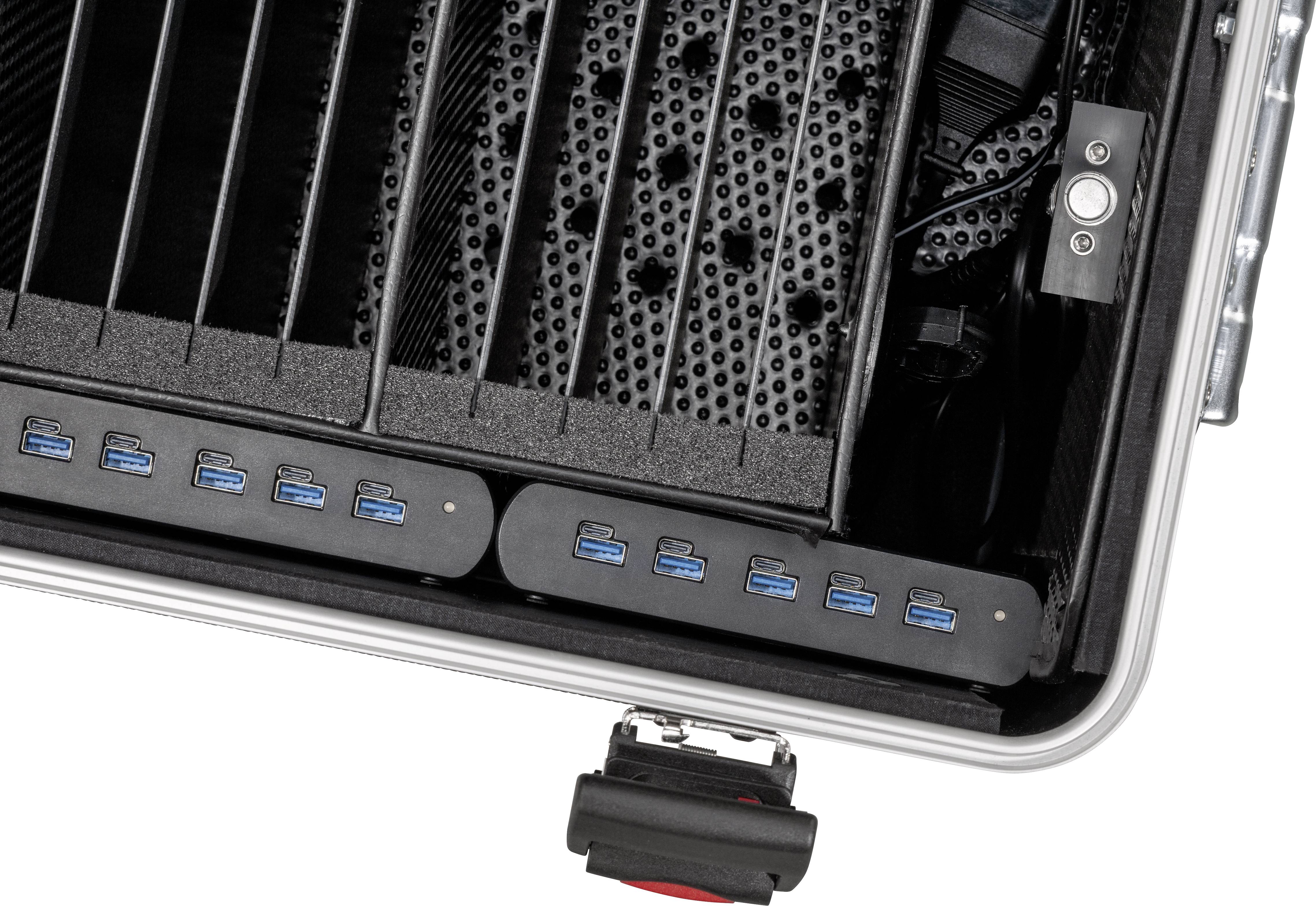 Otwarty kufer z portami USB i przegródkami na urządzenia elektroniczne. Kufer oferuje miejsce do przechowywania i możliwości podłączenia sprzętu.