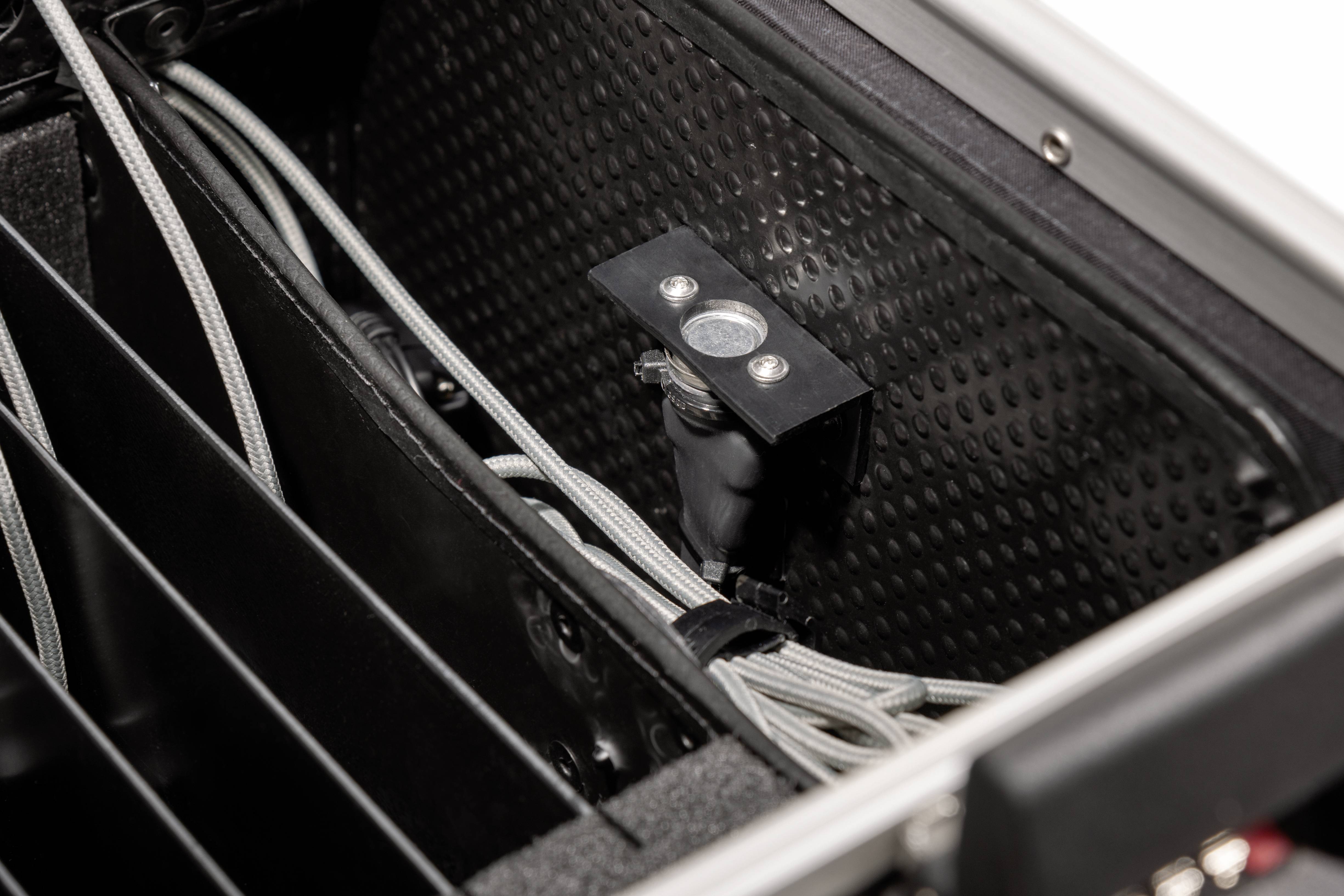 Widok wewnętrzny obudowy technicznej przedstawia zarządzanie przewodami oraz zamontowany obiektyw stosowany w zastosowaniach optycznych.