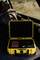 Żółta twarda walizka z otwartą pokrywą, w której znajduje się urządzenie w kolorach czerwonym i czarnym oraz dwie małe czarne części dodatkowe, umieszczona w tylnej części samochodu.