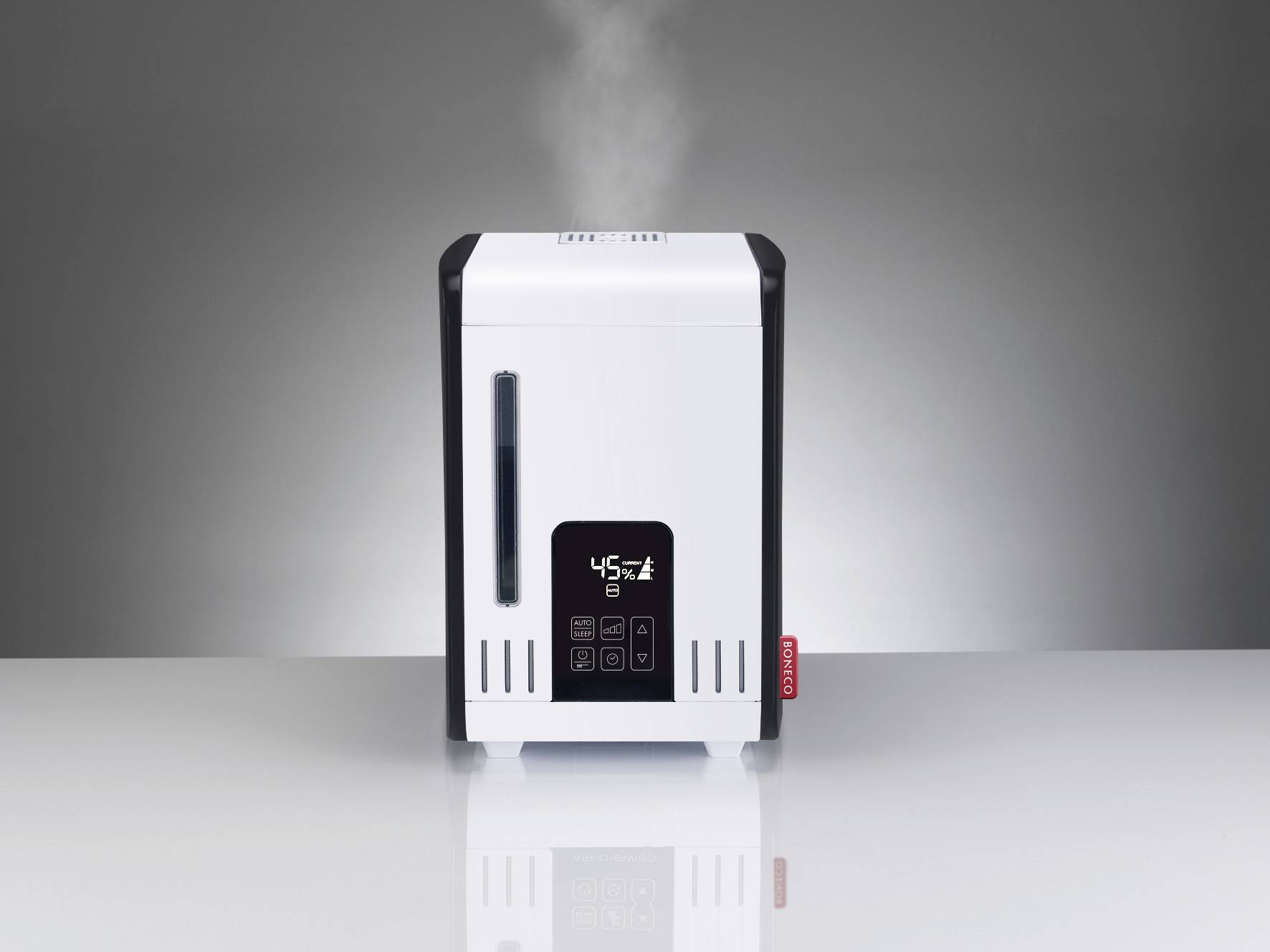 Nawilżacz powietrza stojący na stole, z której wznosi się para wodna. Na wyświetlaczu widać '45%'. Czarne elementy, białą obudowę, szare tło.