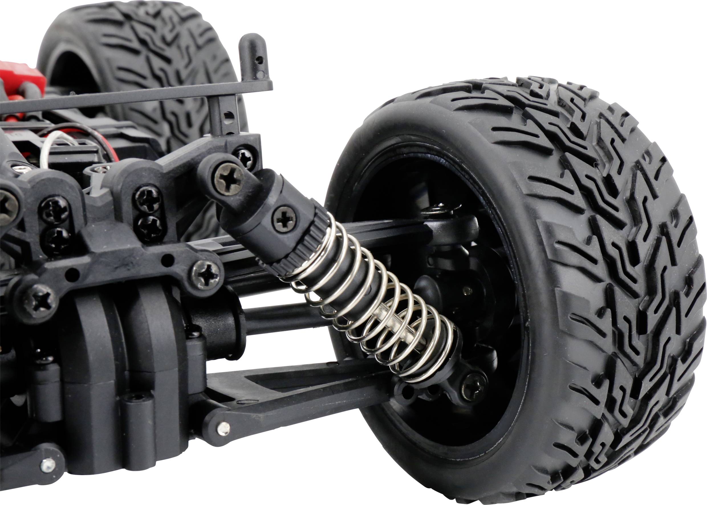 Zbliżenie zdalnie sterowanego samochodu, ze szczególnym uwzględnieniem przedniej opony i zawieszenia. Widoczne szczegółowe elementy mechaniczne.