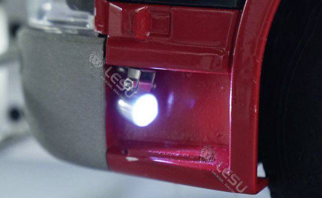 Zbliżenie urządzenia pomalowanego na czerwono, z jasnym światłem emitowanym przez małą diodę LED; fokus na świetle.