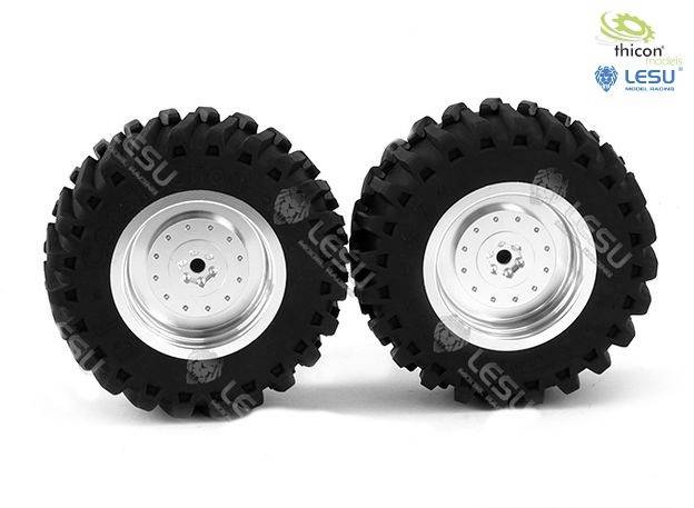 Dwa duże czarne opony terenowe z metalowymi felgami na białym tle. Widoczne są logo marek 'Thicon' i 'Lesu'.