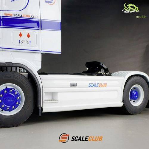 Modelowy samochód ciężarowy w białym i niebieskim kolorze z napisem 'SCALECLUB' na boku, ustawiony przed neutralnym tłem.