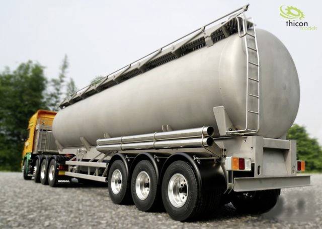 Srebrny przyczepa do przewozu paliwa na terenie żwirowym. W tle widoczne drzewa. Logo marki w górnym prawym rogu.