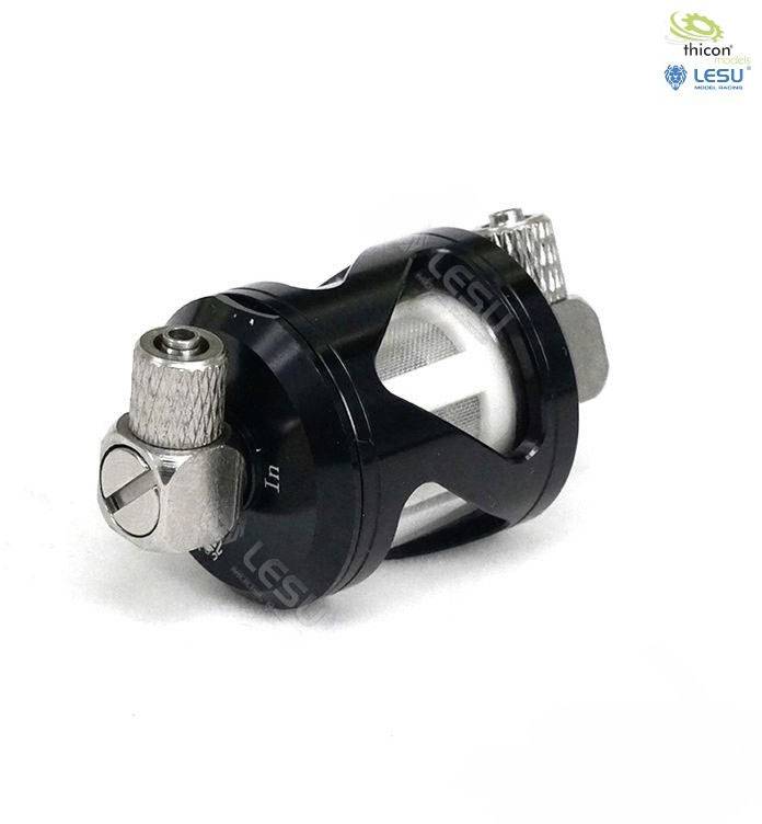 Czarno-srebrowy cylinder metalowy z zaworami przyłączeniowymi na obu końcach. Jego wnętrze jest częściowo widoczne i zawiera kratkę.