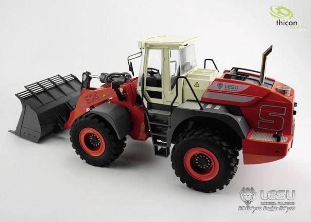 Czerwony przemysłowy ładowarka kołowa z dużym osprzętem ładowarkowym. Na karoserii logo i napis: 'LESU 574'.