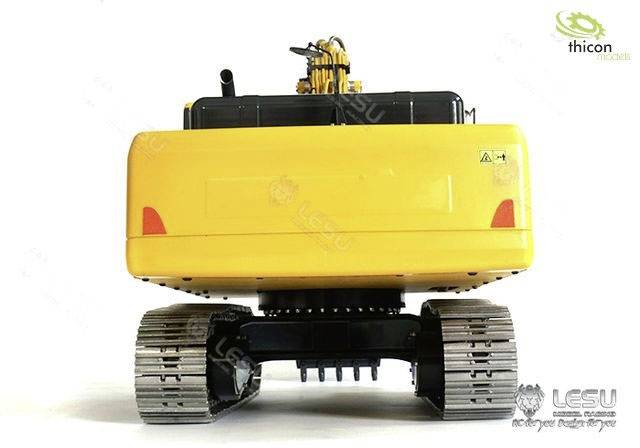 Żółty model koparki z gumowymi gąsienicami, ukazany z przodu. Logotypy marek 'Thicon' i 'LESU' w prawym górnym i lewym dolnym rogu.