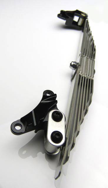 Metalowy element konstrukcyjny z elementami łączącymi, prawdopodobnie część urządzenia mechanicznego lub maszyny.