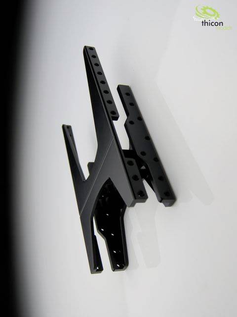 Mocowanie z czarnego metalu zamontowane na ścianie, posiadające kilka otworów mocujących i nowoczesny, geometryczny design.