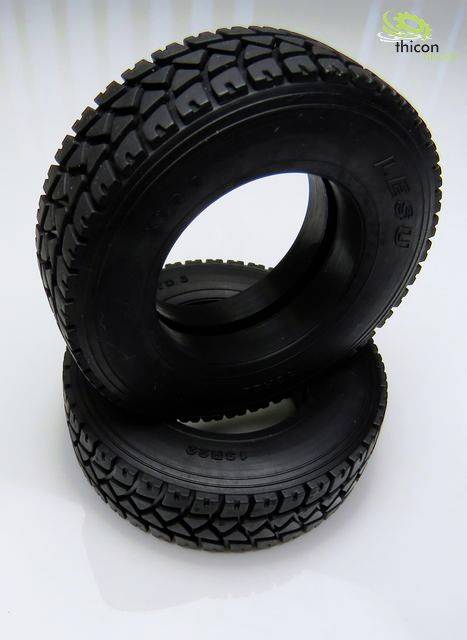 Dwa czarne modelowe opony z grubym bieżnikiem są ułożone jeden na drugim. Po lewej stronie widoczne jest logo z zielonymi elementami.