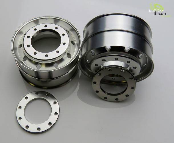 Dwa lśniące metalowe koła z okrągłymi wzorami otworów, wraz z osobną tarczą perforowaną na gładkiej powierzchni.