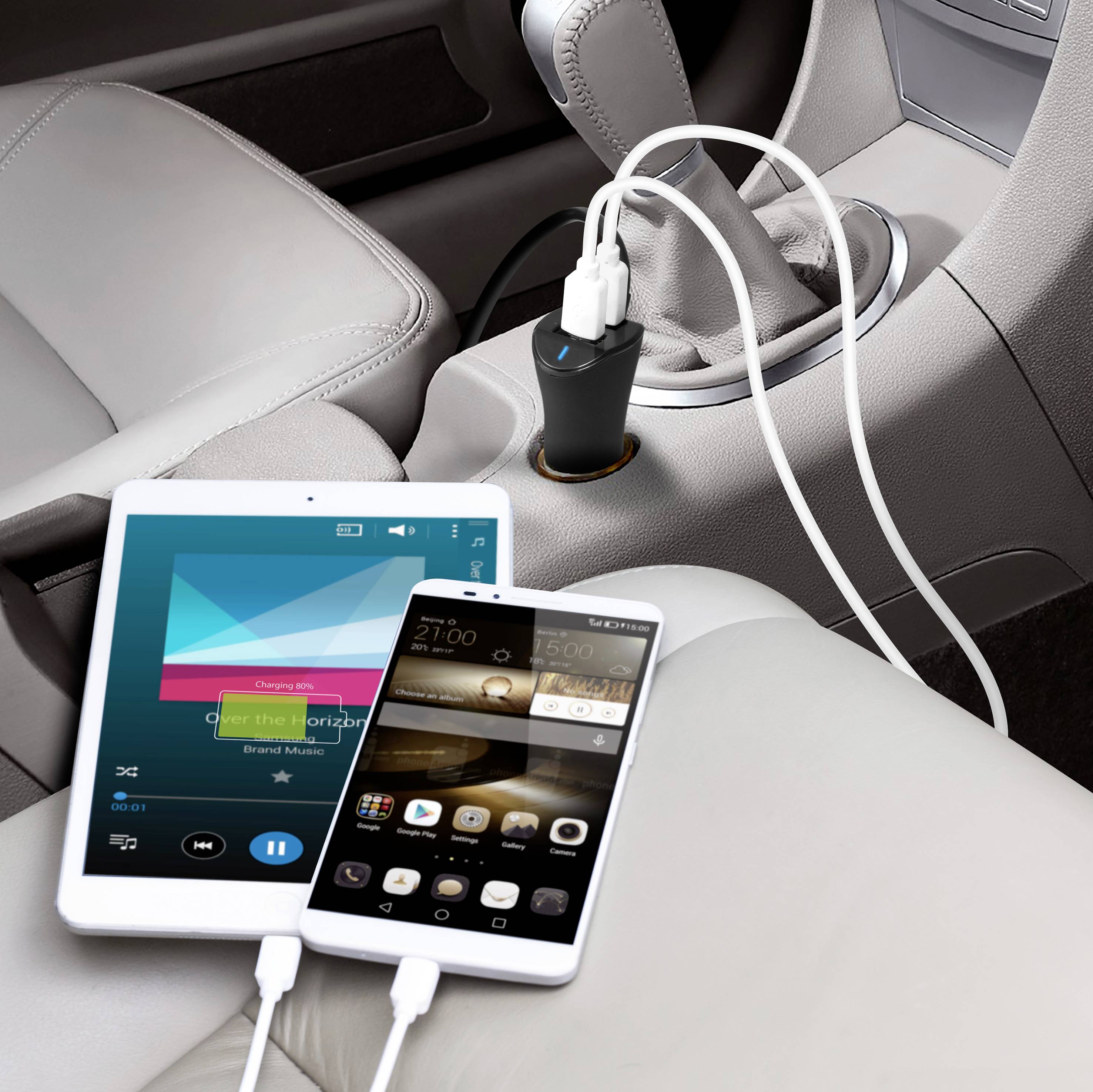Tablet i smartfon ładowane przez ładowarkę USB w samochodzie.