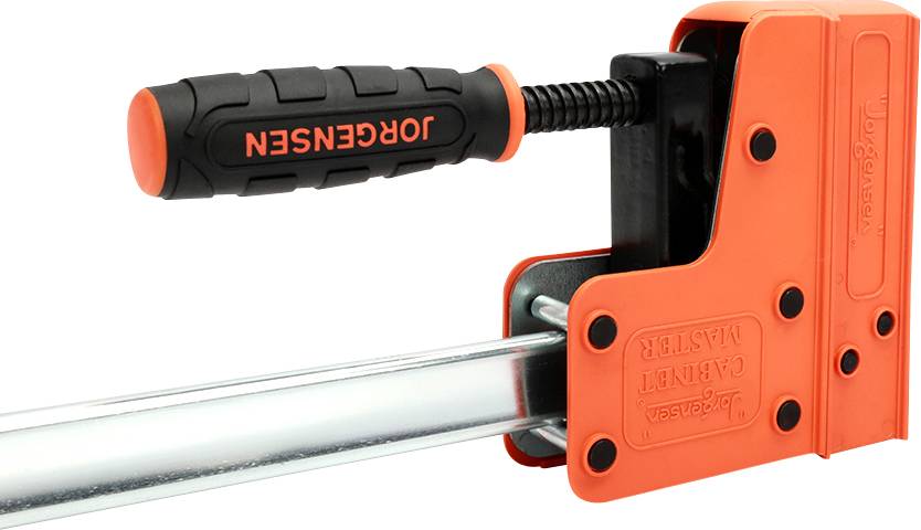 Widoczny jest pomarańczowy ścisk śrubowy z czarną rękojeścią, widziany z boku.