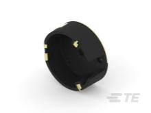 Czarny, cylindryczny pierścień z tworzywa sztucznego z czterema złotymi punktami stykowymi na zewnątrz, prawdopodobnie element elektronicznego złącza lub urządzenia.
