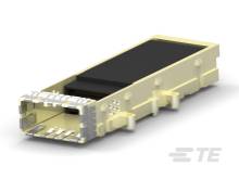 Żółty moduł elektroniczny z metalowymi stykami po jednej stronie leży na białej powierzchni. Wygląda na urządzenie techniczne.