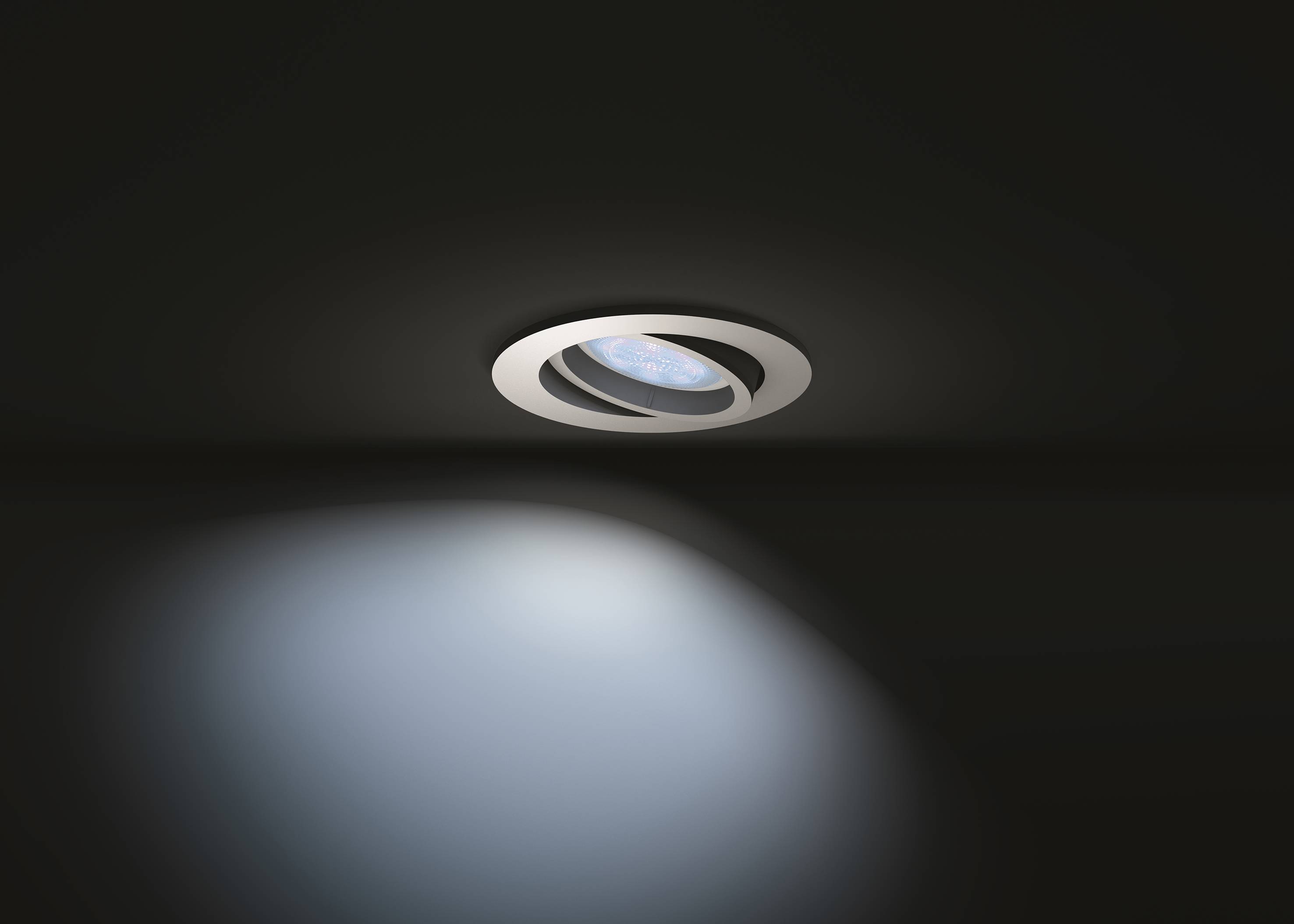 Pojedyncza lampa sufitowa oświetla ciemne pomieszczenie, tworząc łagodny stożek światła na podłodze.