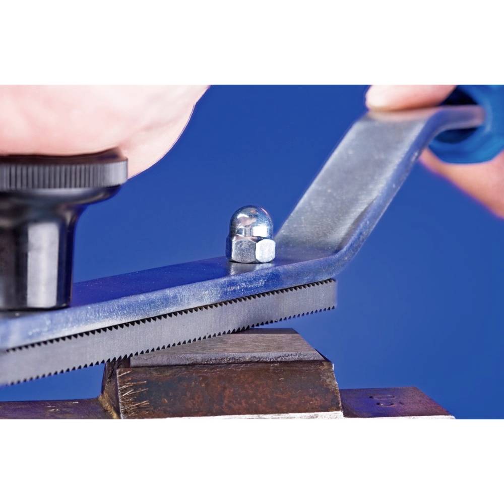 Zbliżenie metalowej piły na kowadle, trzymanej przez jedną rękę. Druga ręka obraca pokrętło, regulując grubość piłowania.