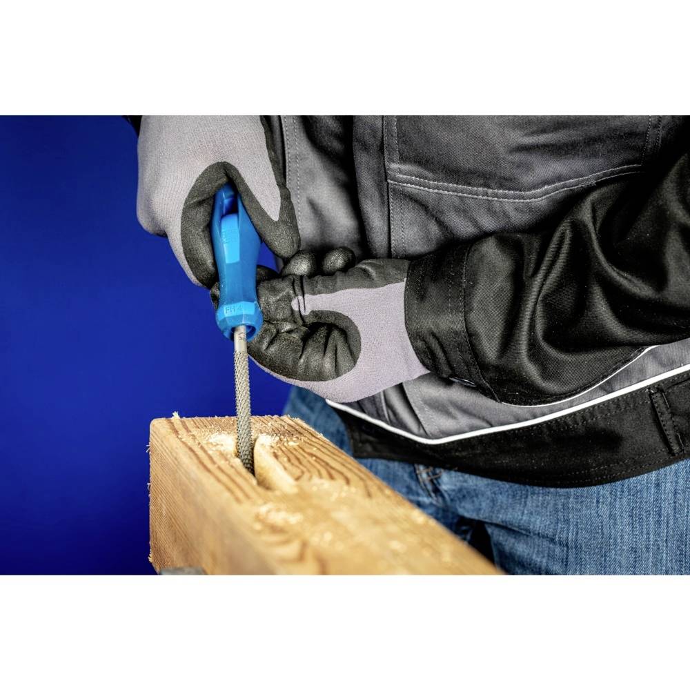 Osoba piluje prostokątny otwór w desce drewnianej za pomocą niebieskiej metalowej piły. Ma na sobie rękawice i czarną kurtkę.