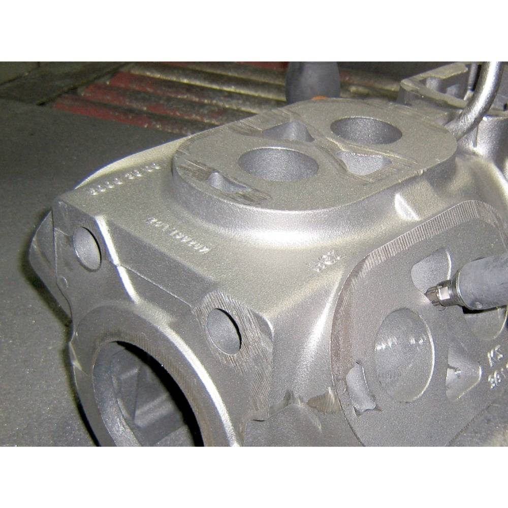 Odlew metalowy z cylindrycznymi otworami i mocowaniami śrubowymi, prawdopodobnie element systemu budowy maszyn.