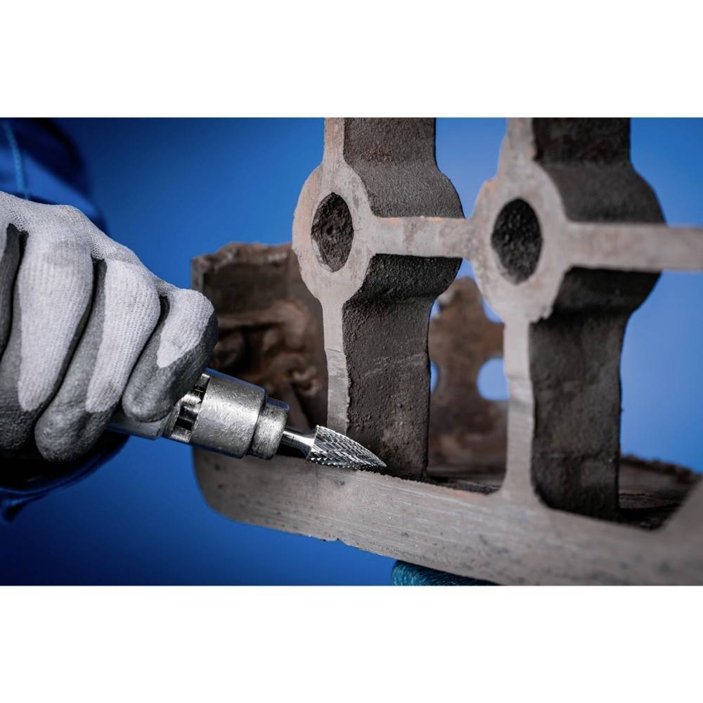 Zbliżenie pracownika w rękawicach obrabiającego powierzchnię metalową narzędziem rotacyjnym.