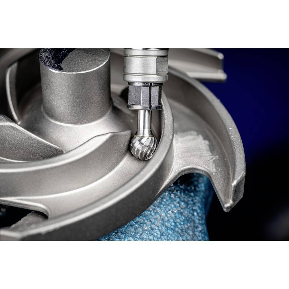 Frezarka obrabia część metalową z bliska. Gładka, błyszcząca powierzchnia świadczy o precyzyjnym wykonaniu.