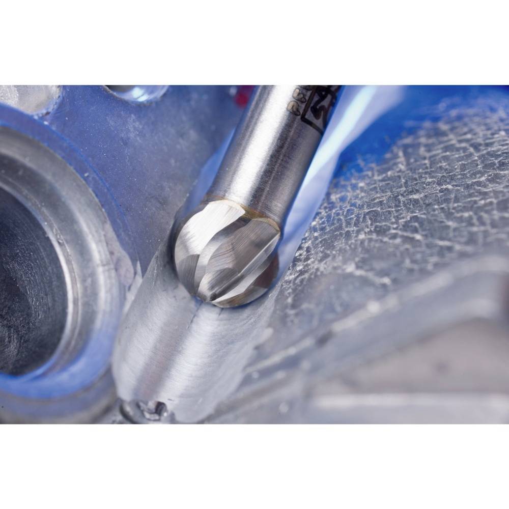 Zbliżenie narzędzia obrabiającego metal. Narzędzie to frez, który jest wprowadzany w obrabiany element. Środowisko techniczne.