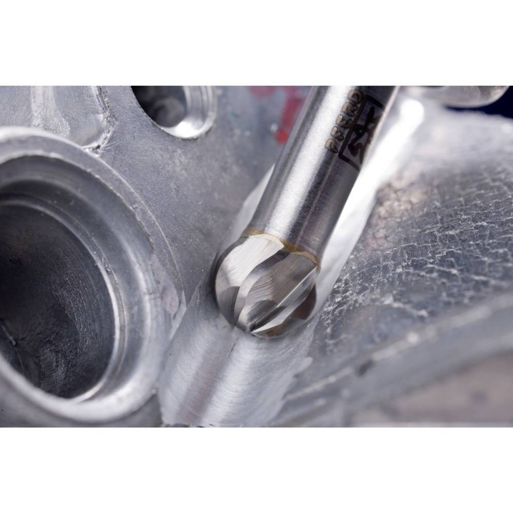 Zbliżenie wiertła obrabiającego kawałek metalu. Wiertło porusza się, precyzyjnie wycinając otwory w materiale.