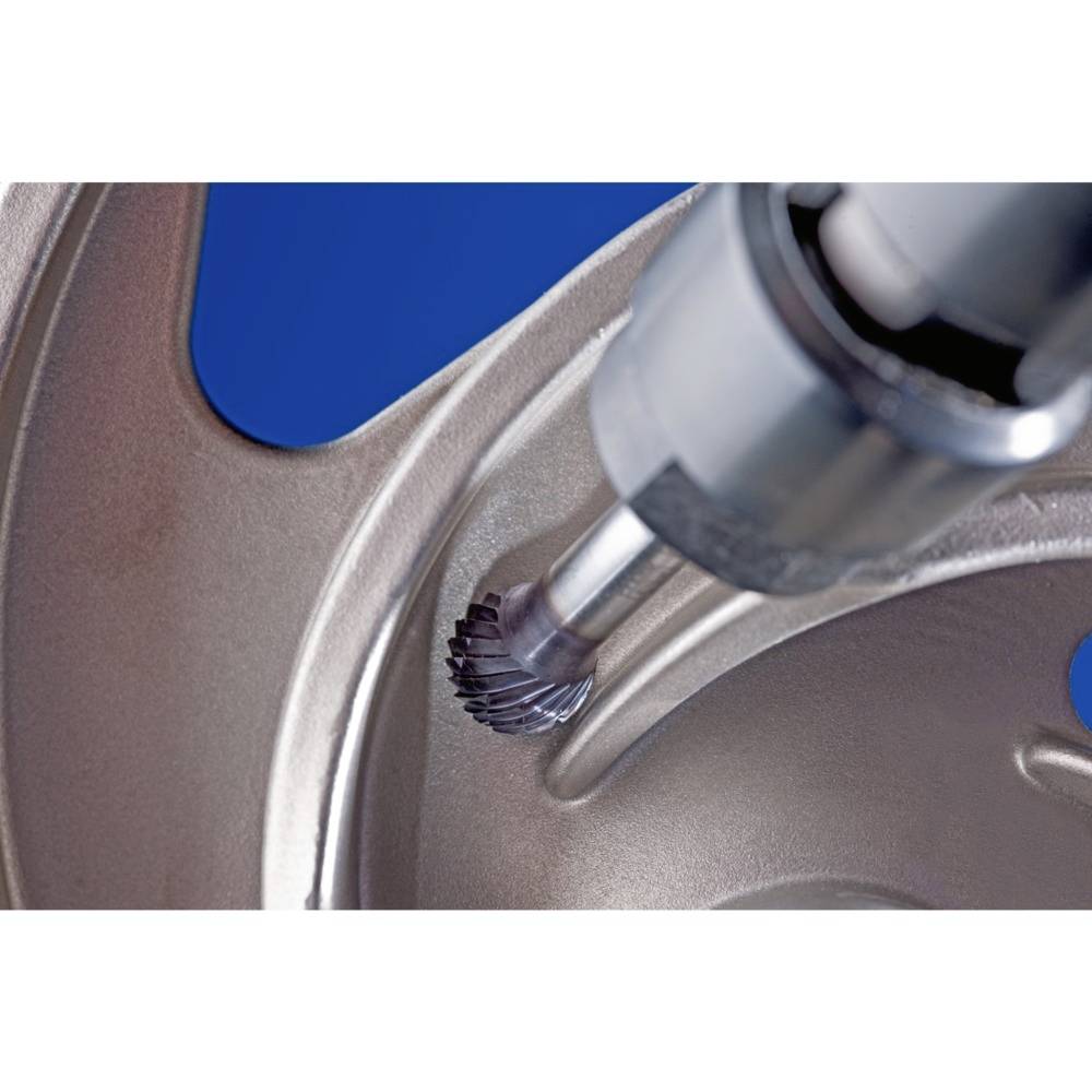 Zbliżenie narzędzia metalowego kształtującego gładkie wcięcie na metalowej powierzchni; widoczna precyzyjna techniczna dokładność.