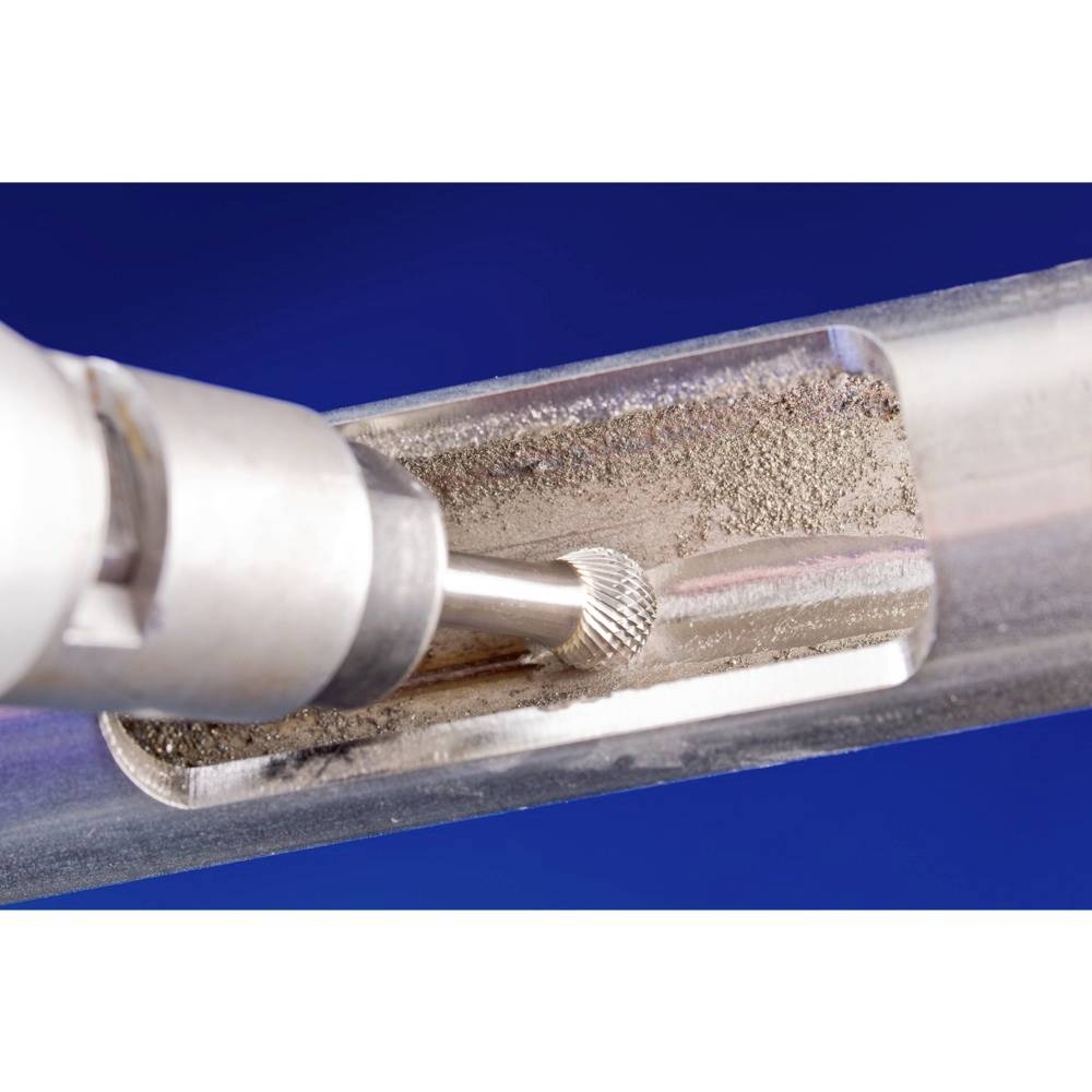 Obracające się narzędzie obrabia metalową rurę. Usuwa wióry z wewnętrznej ścianki, co wskazuje na precyzyjną obróbkę.