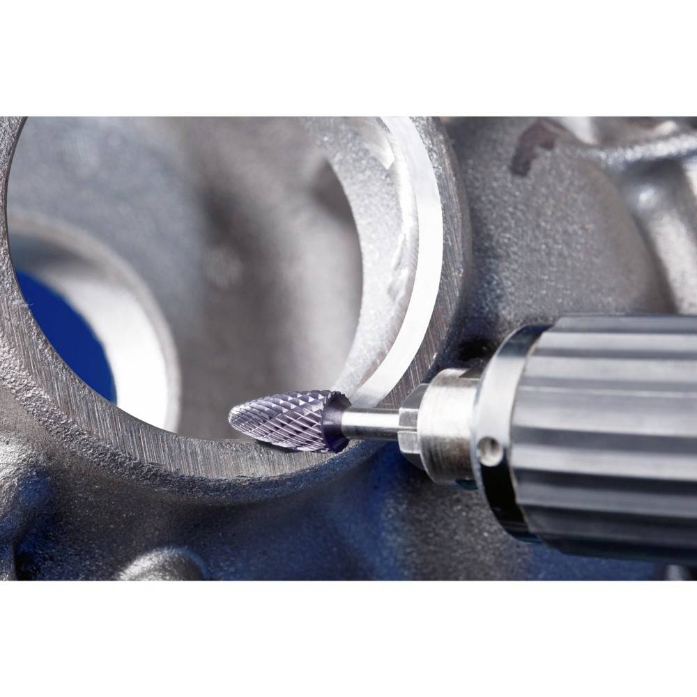 Wiertło obrabia wewnętrzną krawędź metalowej rury. Narzędzie wygładza powierzchnię i usuwa nadmiar materiału.